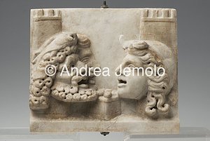 Archaeological National museum Pinax side A, votive tablet, with theatrical masks from the garden nymphaeum of Villa of the Mosaic Columns, marble | Andrea Jemolo