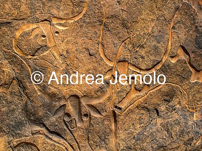  Rock engraving depicting a herd of moving elephants and under a group of men - Tassili n'Ajjer, Tadart Rouge | Andrea Jemolo
